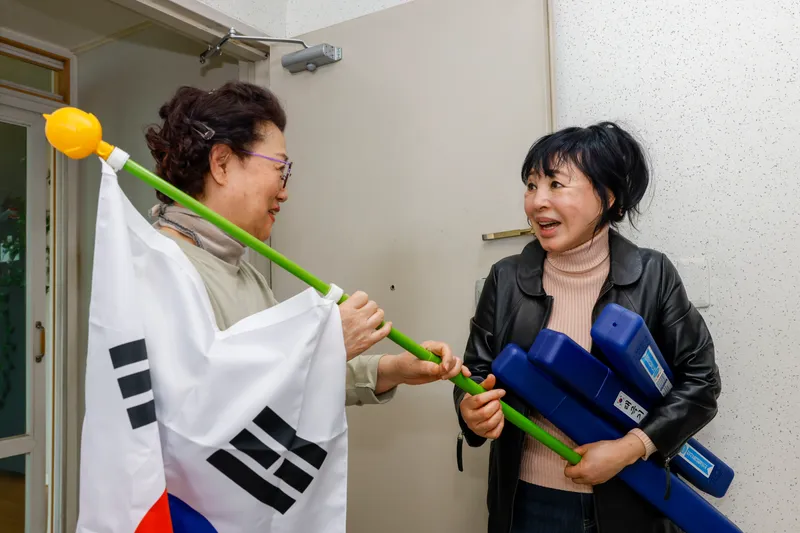 사진 1. 김금숙(오른쪽) 무성아파트 이장이 주민에게 직접 태극기를 전달하며 태극기 달기 운동 참여를 독려하고 있다.